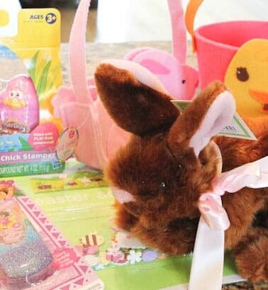 Easter basket supplies: brown fluffy bunny, PlayDoh stamps, duck basket, bunny basket, and dora phone