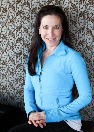 Marla sitting in front of patterned wall with blue jacket