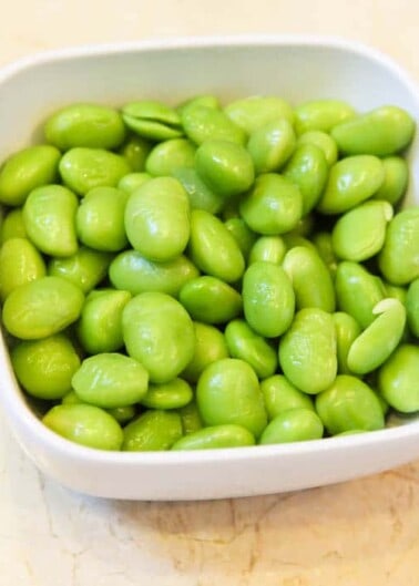 A bowl of fresh, green shelled edamame beans.