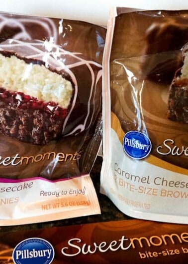 Two packages of pillsbury sweet moments bite-size brownies in raspberry cheesecake and caramel cheesecake flavors.