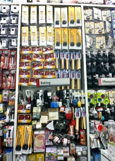 An aisle in a store stocked with various baking utensils and measuring tools.