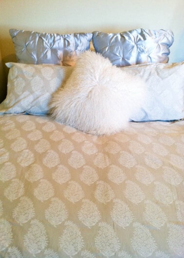 A neatly made bed with decorative pillows.