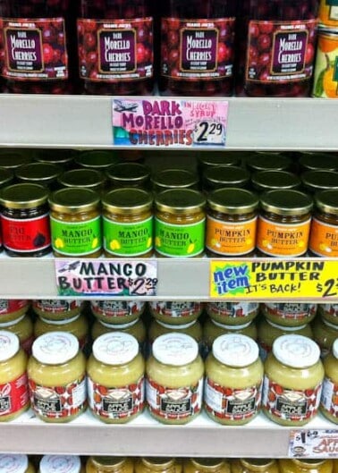 Shelves stocked with various jars of fruit preserves and butters with visible price tags.