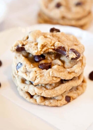 Stack of chocolate chip cookies on a white surface.