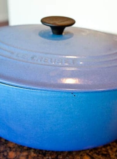 Blue enameled cast iron dutch oven on a kitchen countertop.