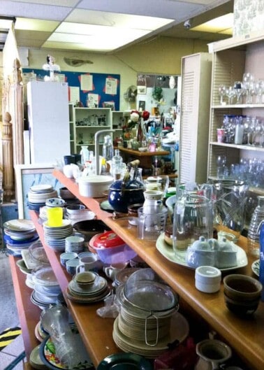 Cluttered thrift store with an assortment of second-hand items on display.