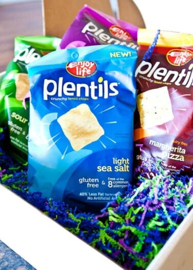 Three bags of plentils crunchy lentil chips in different flavors displayed in a gift box with decorative filling.