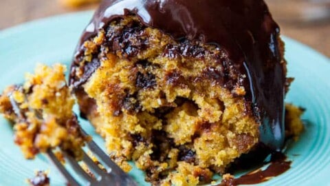 A serving of sticky toffee pudding with sauce on a blue plate.