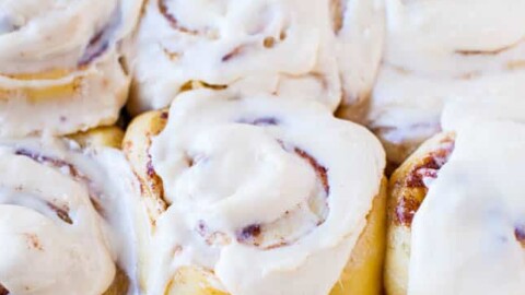 Freshly baked cinnamon rolls topped with white icing.