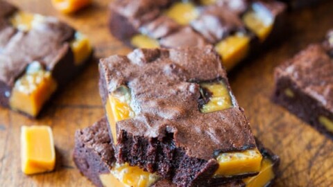 Sliced caramel brownies on a wooden surface.