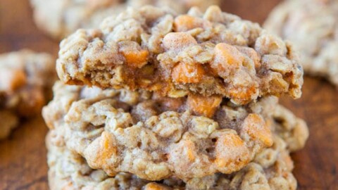 A stack of oatmeal cookies with butterscotch chips on a wooden surface.