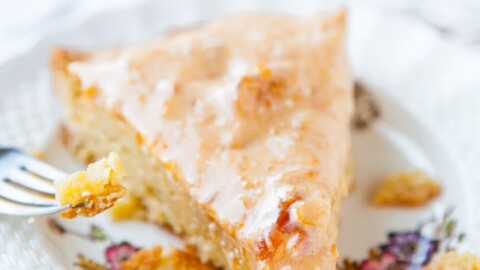 A slice of glazed pie on a decorative plate with a fork.