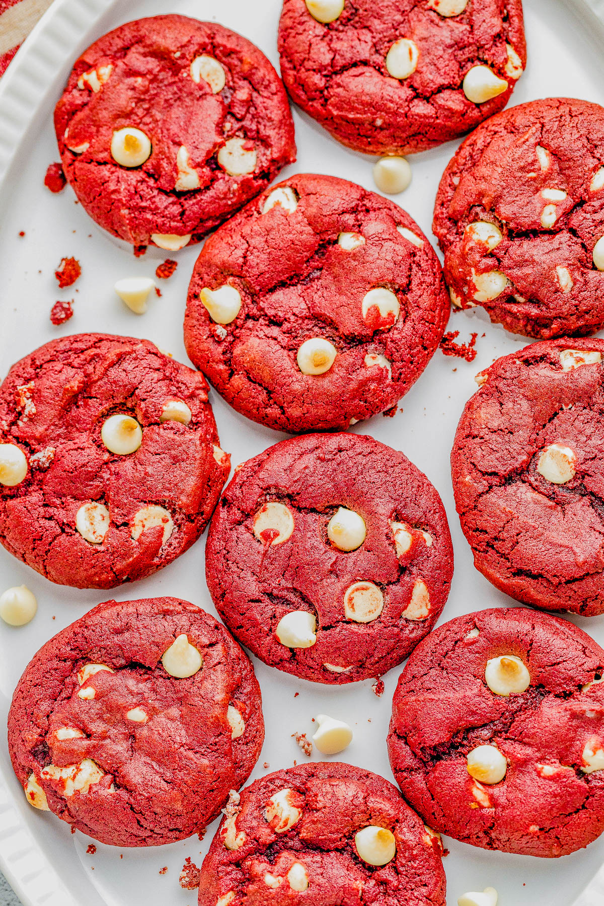 Plate of red velvet cookies with white chocolate chips arranged in a circle.