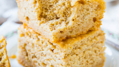 A stack of freshly baked cornbread slices on a decorative plate.