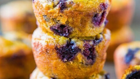 A stack of blueberry muffins with visible berries and a golden-brown crust.