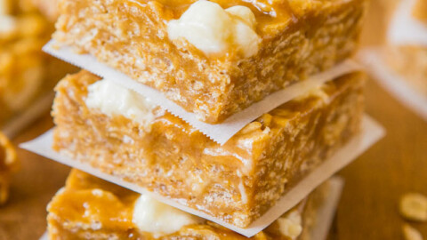 Stack of peanut brittle squares on parchment paper.