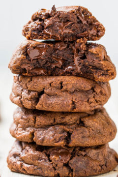 A stack of gooey chocolate cookies on a light surface.