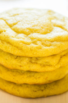 Stack of lemon cookies on a wooden surface.