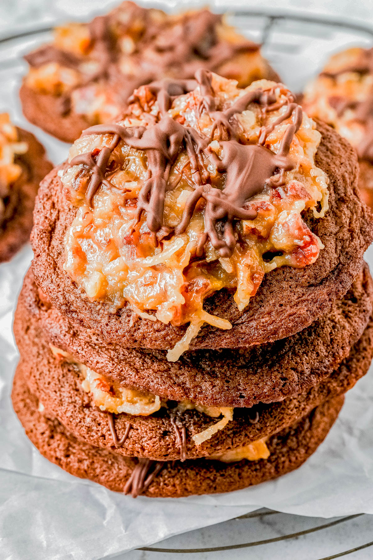 A stack of chocolate cookies topped with a coconut and chocolate drizzle.