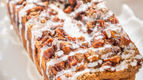 Glazed pecan-topped loaf on a white plate.