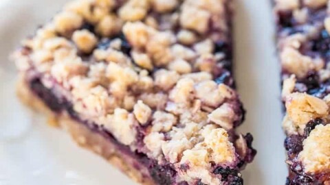 A slice of blueberry crumble pie on a white plate.