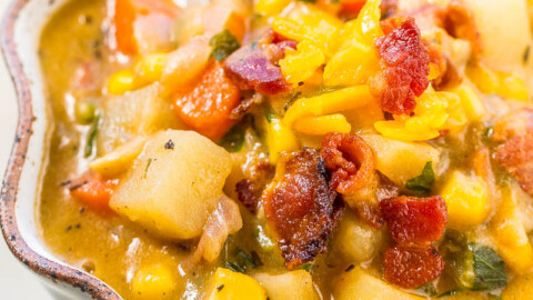 Hearty vegetable and bacon stew served in a decorative dish.