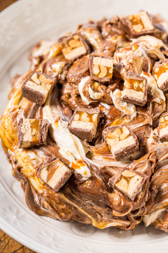 A bowl of Snickers dip topped with Snickers pieces. 