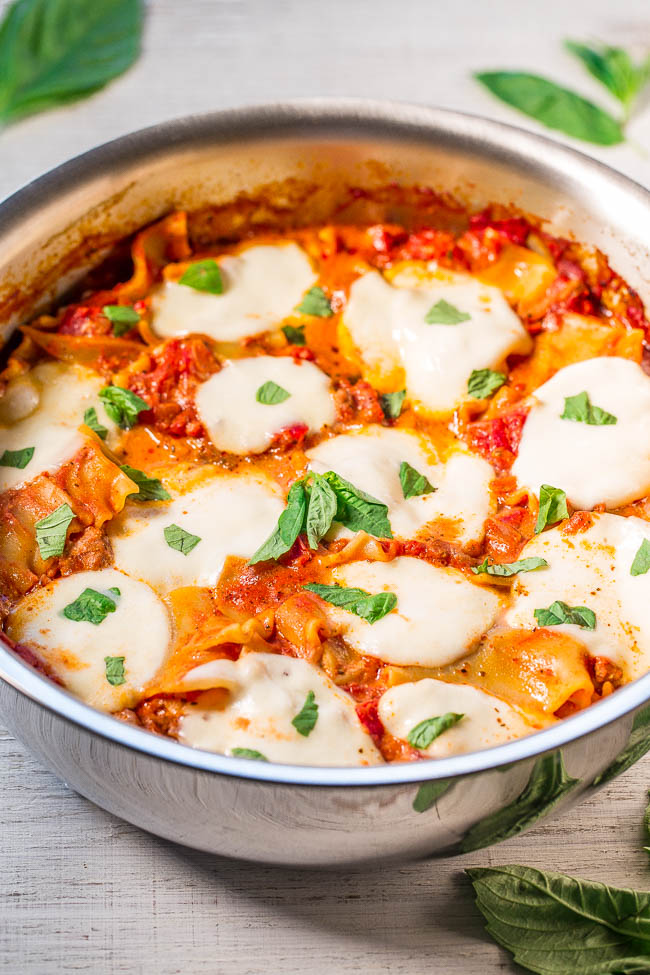 A pan of baked pasta with tomato sauce, mozzarella cheese, and fresh basil.