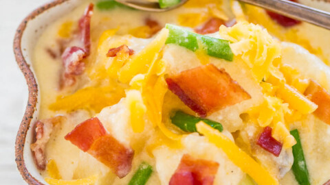 Loaded baked potato soup topped with cheese, bacon, and green onions in a bowl.