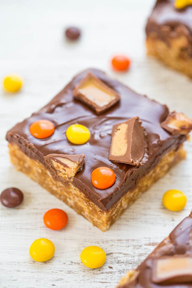 Homemade candy bar-inspired dessert square with toppings on a wooden surface.