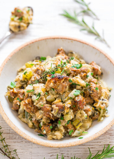 A bowl of stuffing garnished with fresh herbs.