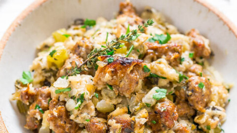 A bowl of stuffing garnished with fresh herbs.