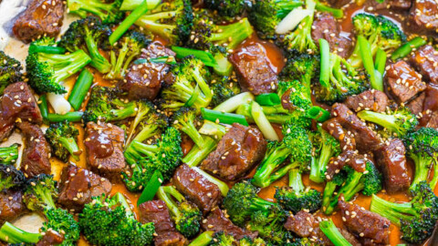 A baking sheet filled with roasted broccoli and chunks of beef covered in a glaze.