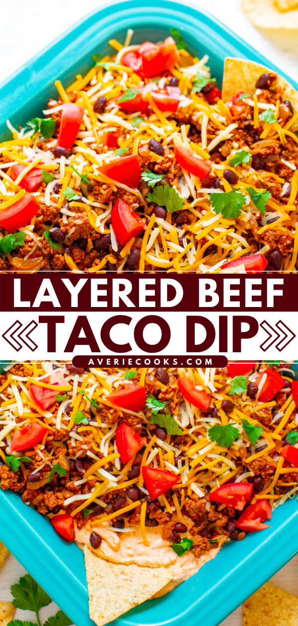 A dish of layered beef taco dip topped with shredded cheese, chopped tomatoes, beans, and cilantro on a blue rectangular plate.