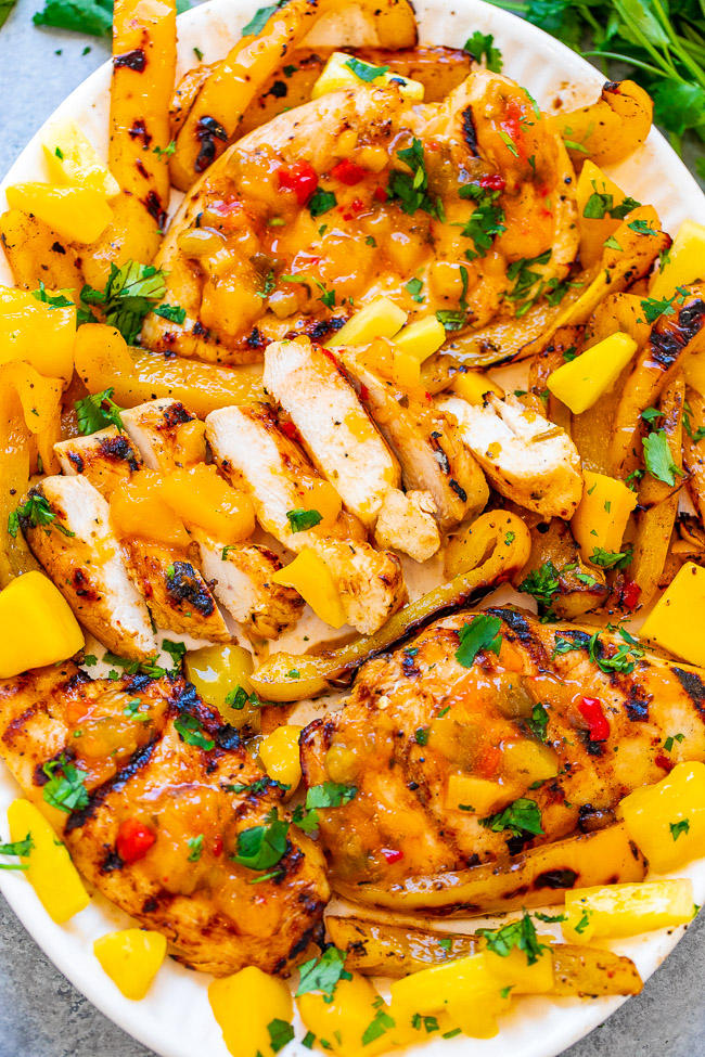 Grilled Mango Pineapple Chicken - EASY, ready in 10 minutes, and the flavor of the juicy chicken makes you feel like you're on a TROPICAL island!! Grilled peppers on the side makes for the PERFECT summer meal that's HEALTHY and DELICIOUS!!