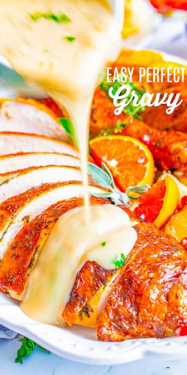 Gravy being poured over sliced roasted turkey garnished with orange slices and herbs. Text overlay says "Easy Perfect Gravy.