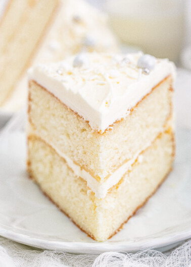 White Layer Cake - A classic, white, two-layer cake recipe for cake with a light texture that's complemented by super light and fluffy buttercream that's not too sweet! Learn how to make THE BEST white layer cake that's fancy enough to serve at your most special celebrations and events!