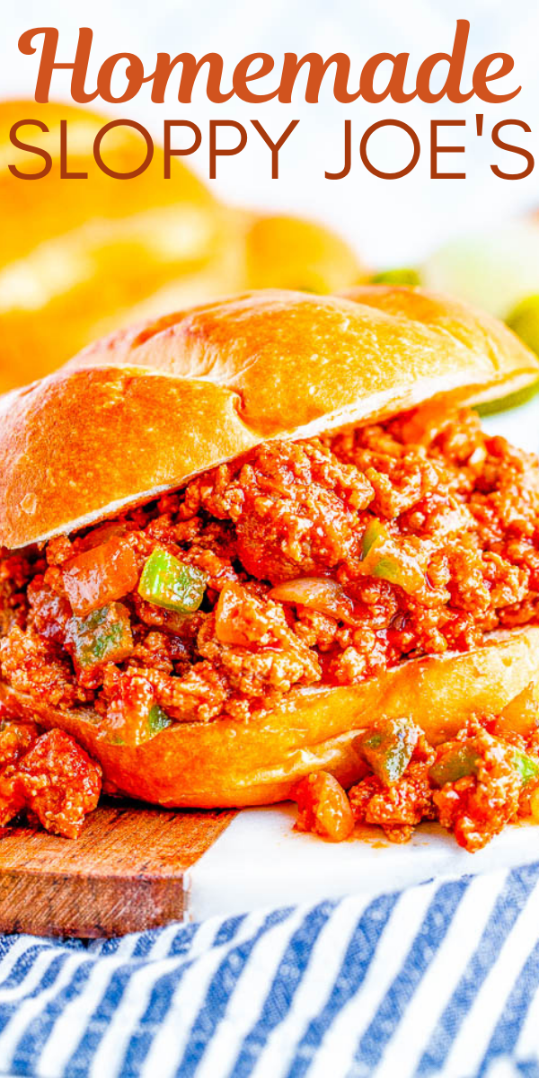 Close-up of a Sloppy Joe sandwich with a filling of seasoned ground meat and vegetables in a bun, placed on a wooden board with a striped cloth below. Text at top reads "Homemade Sloppy Joe's.