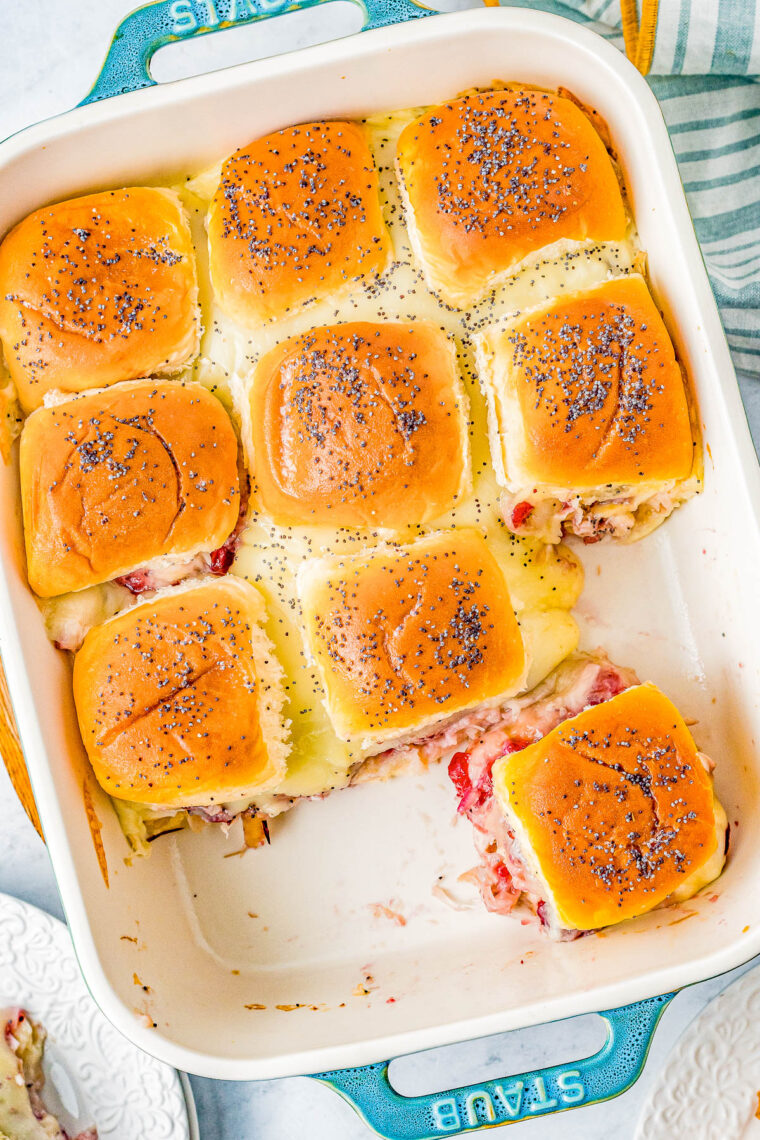 Turkey and Cheese Sliders - Juicy turkey, Swiss cheese, and cranberry sauce all nestled in soft Hawaiian rolls that are brushed with butter and topped with poppy seeds for the BEST turkey sliders! FAST, EASY, and takes advantage of leftover turkey! Deli turkey also works.