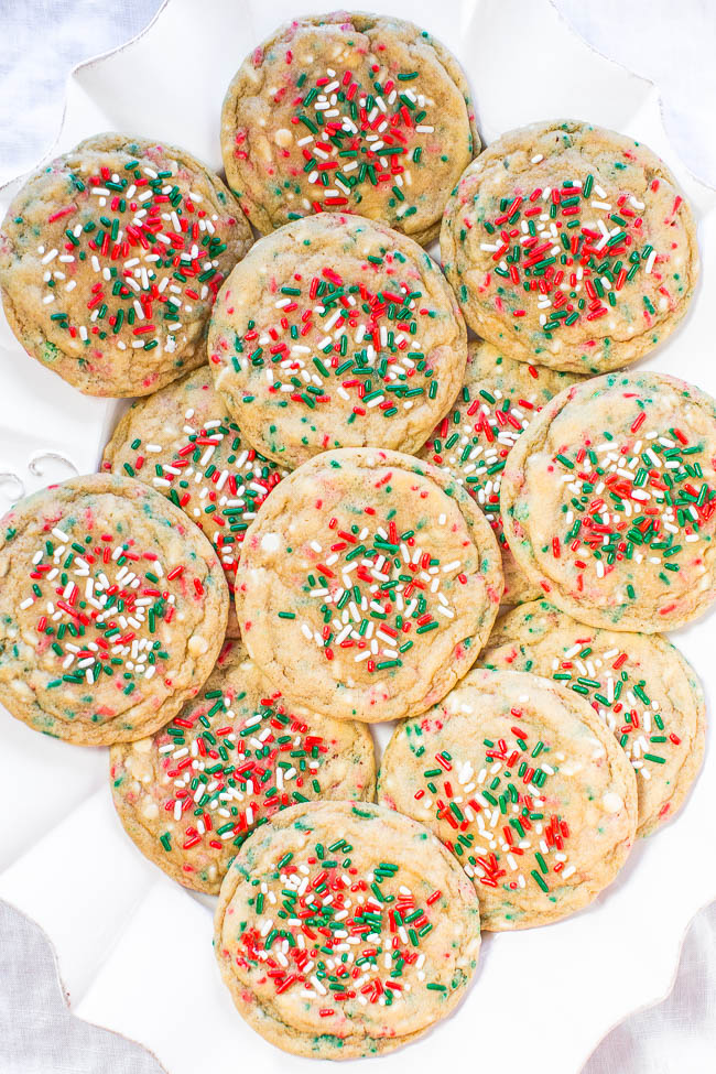 A plate of round cookies topped with red, green, and white sprinkles.