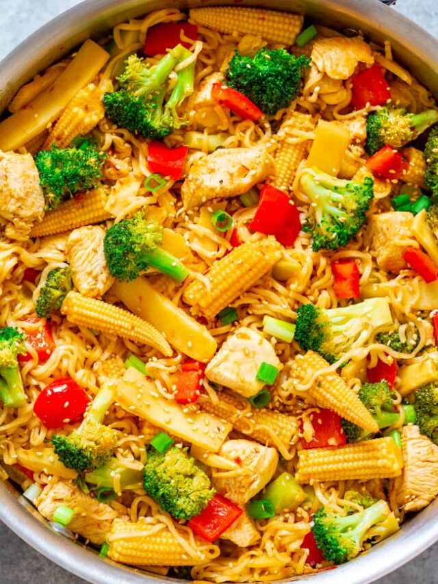 A colorful stir-fry with chicken, vegetables, and noodles in a pan.