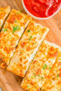 Easy Cheesy Garlic Bread - French bread that's been brushed with melted garlic butter and Italian seasoning, then topped with mounds of mozzarella and Parmesan cheeses, and baked to perfection is what this EASY appetizer, snack, or side is all about! Garlic bread with cheese is a family favorite that no one can resist and ready in just 15 minutes!