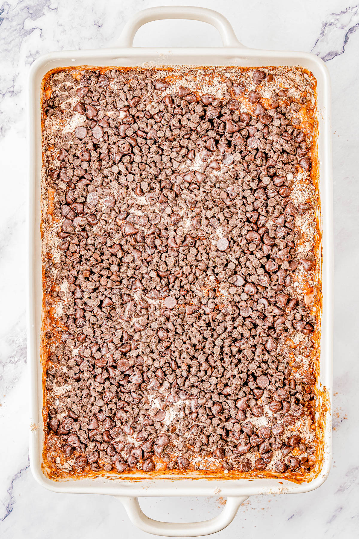 A rectangular baking dish filled with a baked dessert topped with a thick layer of chocolate chips.