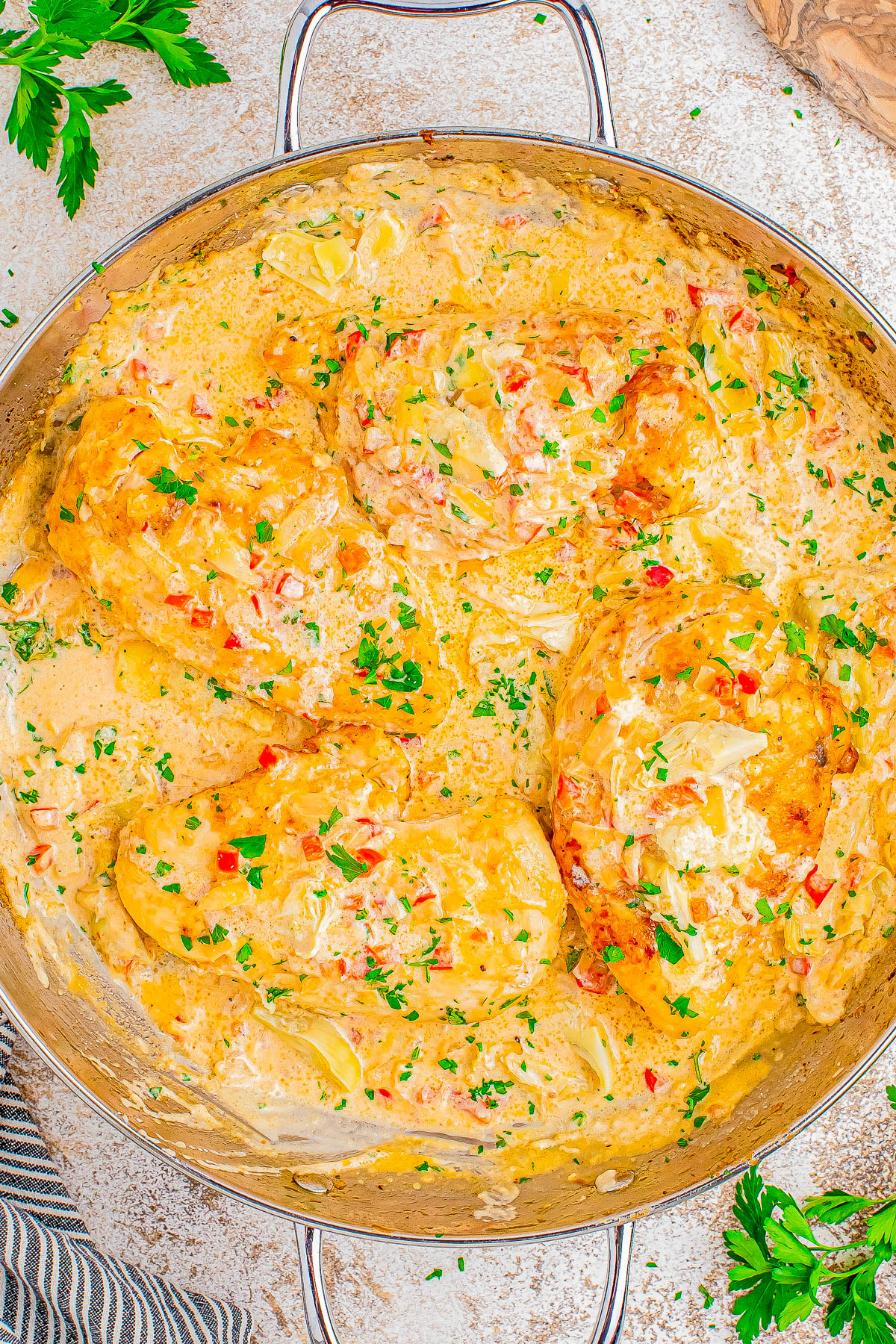 Creamy Parmesan Lemon Chicken Skillet - 🧀🍋🙌🏻 A decadent tasting yet FAST and EASY chicken skillet recipe that's sure to impress your family and friends! Tender lemony chicken, onions, red bell peppers, artichoke hearts, and melted Parmesan cheese with a rich cream sauce for a winner of a chicken dinner! Made in ONE skillet, ready in 30 minutes, and the perfect recipe to jazz up chicken breasts on busy weeknights!