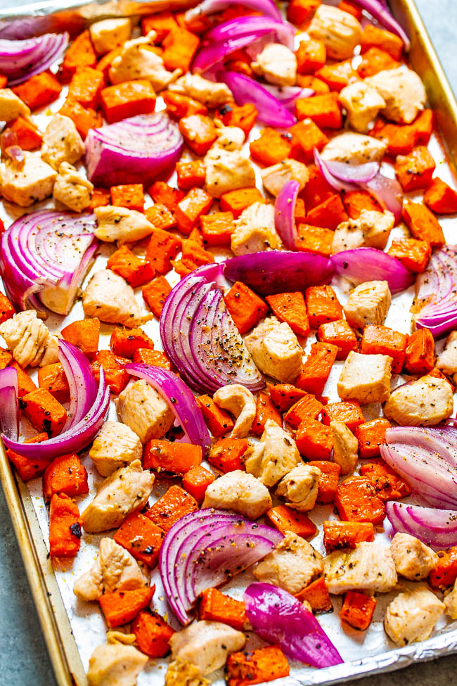 red onion, chicken and sweet potato cubes on a baking tray