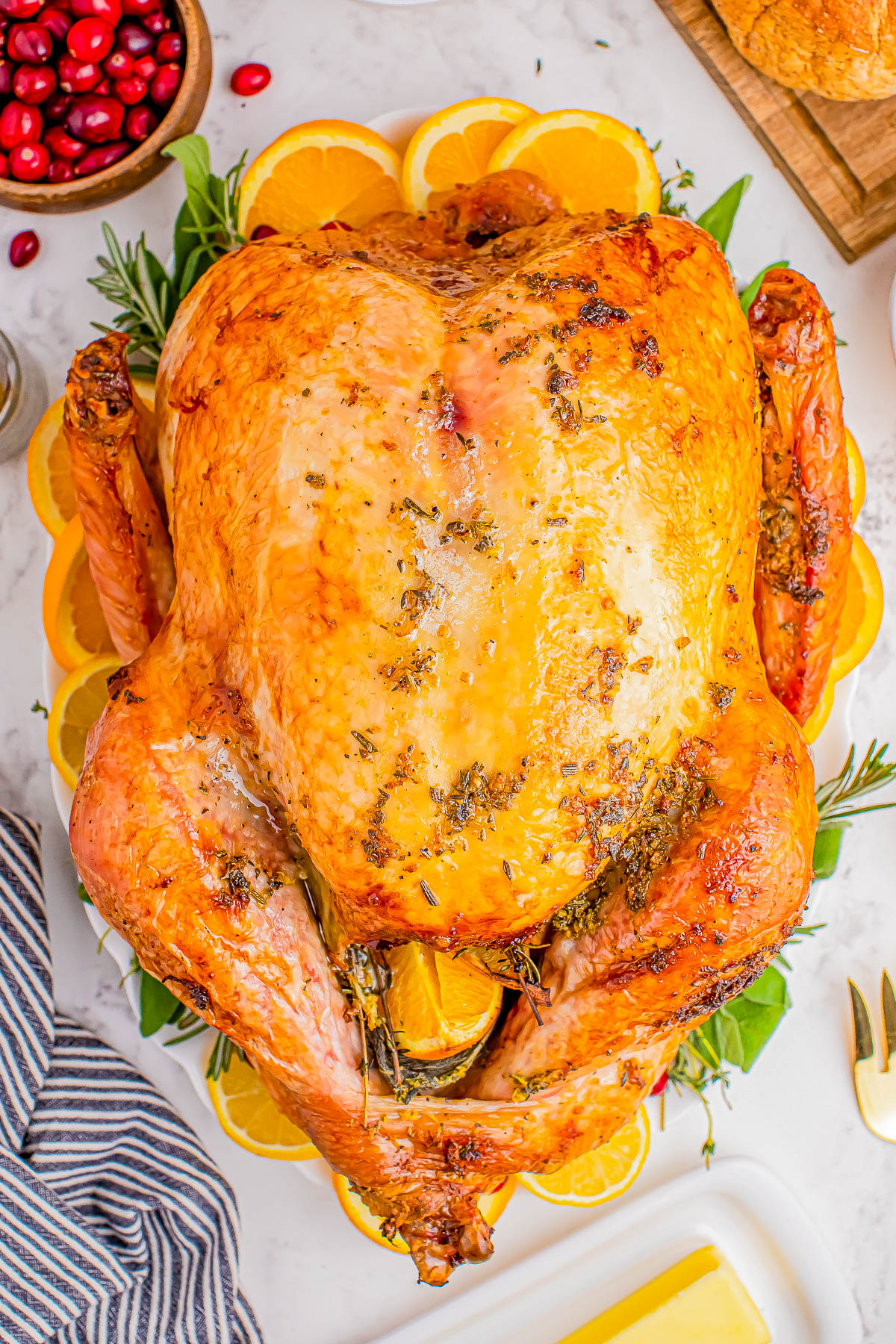 A roasted turkey garnished with slices of orange on a platter.