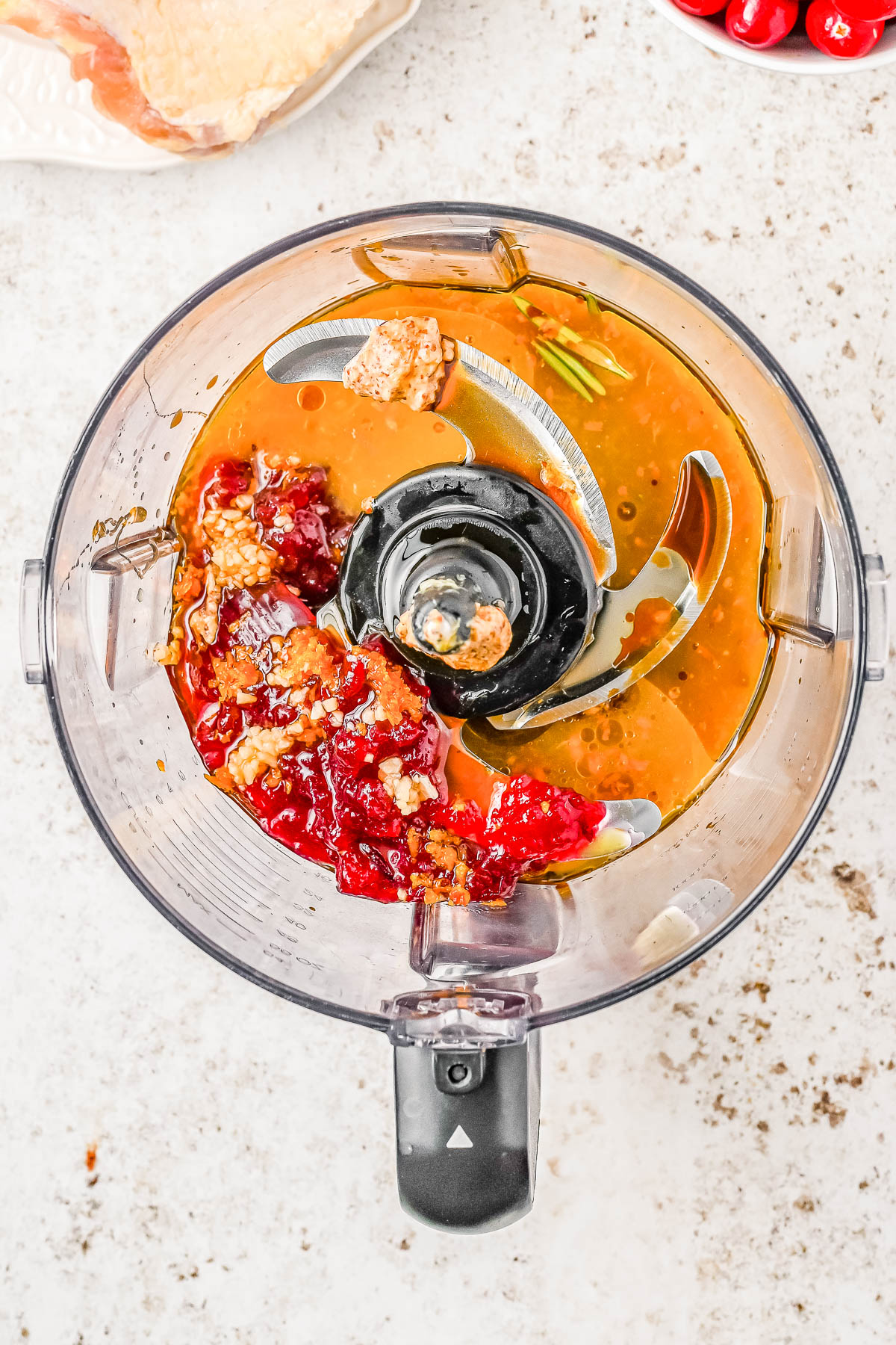 Close-up of a food processor containing ingredients like peanut butter, jelly, and other condiments, ready for blending.